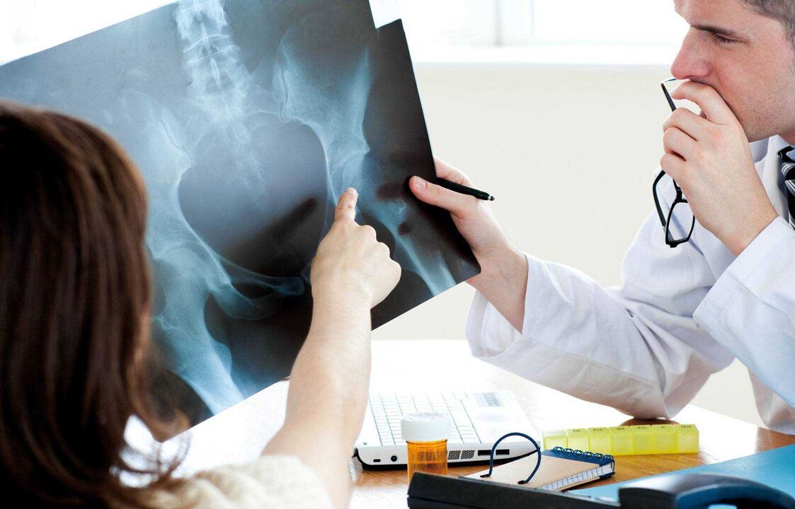 doctor examines x-ray for hip arthrosis